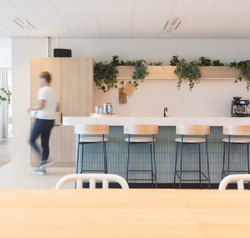 Moderne kantoorkeuken aan de Mt. Lincolnweg met hoge stoelen, hangplanten en een koffiemachine.